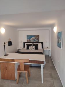イメロヴィグリにあるAmaze Suitesのベッドルーム1室(ベッド1台、木製テーブル付)