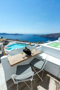 a patio with a table and chairs next to a swimming pool at Amaze Suites in Imerovigli