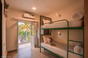 two bunk beds in a room with a window at Zostel Goa (Anjuna) in Anjuna