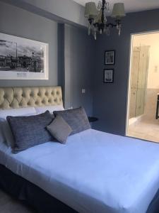 a bedroom with a large white bed with two pillows at Maitre Hotel Boutique in Buenos Aires