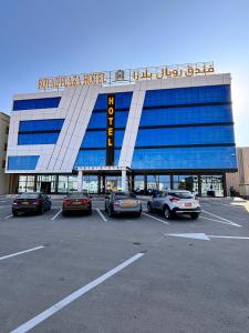 a parking lot with cars parked in front of a building at Royal Plaza Hotel in Duqm