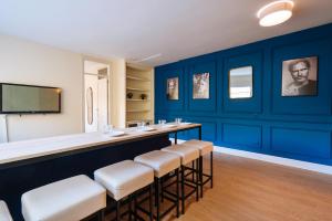 un bar en una habitación con paredes y taburetes azules en The Zentral Suites & Apartments, en Sevilla