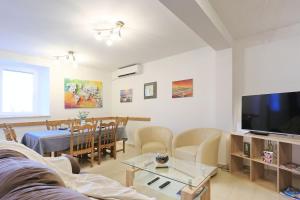 ein Wohnzimmer mit Couch und ein Esszimmer in der Unterkunft Holiday home Šenta in Ljubač