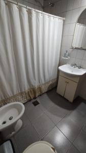 baño con cortina de ducha blanca y lavamanos en Lo de Silvia en Gualeguaychú