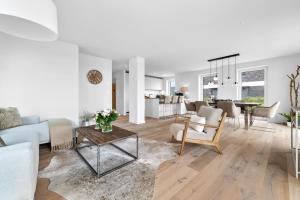 a living room with a couch and a table at Ferienwohnung Nordglanz – Modernes Beachhouse-Flair im Herzen des OstseeResort Olpenitz in Olpenitz