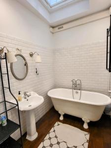 een witte badkamer met een bad en een wastafel bij Studio na Starym Mieście- Hvile Stay in Toruń