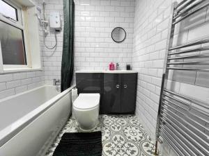 a bathroom with a toilet and a tub and a sink at Flaxton-Luxurious Home near NEC, BHX in Birmingham