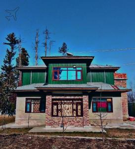 ein großes Haus mit grünem Dach in der Unterkunft Sheraz Guest House Ziran Gulmarg in Gulmarg