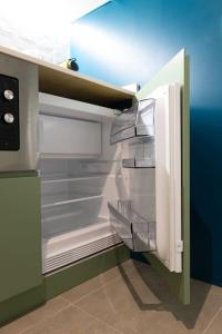 an empty refrigerator with its door open in a kitchen at Estudio moderno y acogedor en Madrid Rio nº6 in Madrid