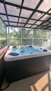 a large bath tub in a room with a window at Charming House with Jacuzzi in Indang