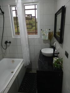 a bathroom with a tub and a sink and a window at Charming House with Jacuzzi in Indang