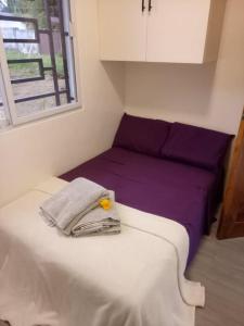 a small bedroom with a bed with a purple blanket at Charming House with Jacuzzi in Indang