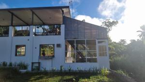 a large white building with windows on the side of it at Charming House with Jacuzzi in Indang