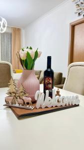 a table with a bottle of wine and a vase with flowers at Vintage De Lux, Top Location, 2Bdr Grand Monastery, Pamporovo in Pamporovo