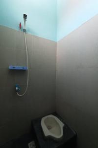 a bathroom with a toilet in a stall at SPOT ON 93465 Archa Guest House Syariah in Jambi