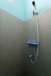a shower with a shower head in a bathroom at SPOT ON 93465 Archa Guest House Syariah in Jambi