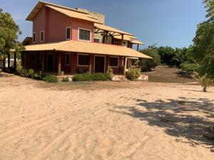 a house on the beach in front of the sand at Casa do Português in Aracati