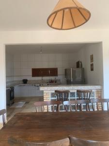 a kitchen with a table and chairs and a light fixture at Casa do Português in Aracati