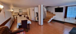 a living room with a table and a kitchen and stairs at Cabana Alina in Păltiniş