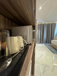 a kitchen with a microwave on top of a counter at Royal Plaza Hotel in Duqm