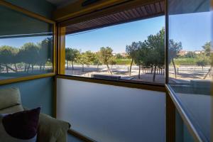 a room with a large window with a view of a park at Estudio moderno y acogedor en Madrid Rio nº7 in Madrid