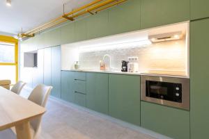 a kitchen with green cabinets and a microwave at Estudio moderno y acogedor en Madrid Rio nº7 in Madrid