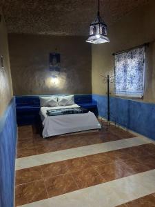 a bedroom with a bed in a blue room at Guesthousefamillytakojt in Merzouga