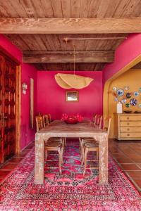 een eetkamer met een tafel en een roze muur bij Casita Suenito in Palm Springs