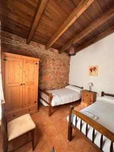 ビリャロブレドにあるCasa del Fraileの木製の天井が特徴のベッドルーム1室(ベッド2台付)