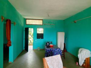 a room with a table and a blue wall at Appat'Adjanohoun in Ouidah