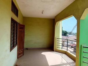 an empty room with a door and a balcony at Appat'Adjanohoun in Ouidah