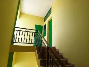 a staircase in a building with a green door at Appat'Adjanohoun in Ouidah