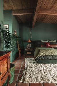 een slaapkamer met groene muren en een bed met een tapijt bij Casita Suenito in Palm Springs