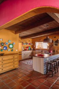 een grote keuken met een roze muur en tafels en stoelen bij Casita Suenito in Palm Springs
