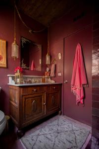 een badkamer met een houten wastafel en een roze muur bij Casita Suenito in Palm Springs