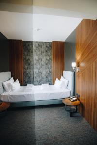 a bedroom with a white bed and a table at Garni Hotel Radović in Kragujevac