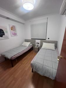 een kamer met 2 bedden en een projectiescherm bij Apartamento en Altea con vistas al mar in Altea