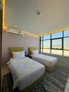 a hotel room with two beds and a large window at Royal Plaza Hotel in Duqm
