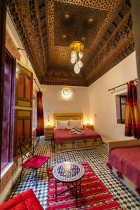 ein Schlafzimmer mit einem Bett und einem Tisch in einem Zimmer in der Unterkunft Riad Fez Qamar in Fès