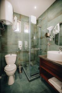 uma casa de banho com um WC, um chuveiro e um lavatório. em Garni Hotel Radović em Kragujevac