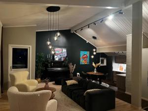 a living room with a couch and a piano at Charming Loft Retreat on Tromsø's Historic Main Street: 3-Minute Stroll to City Square in Tromsø