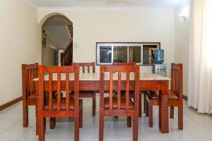 Un comedor con mesa y sillas de madera. en Liya House, Nyali, en Mombasa