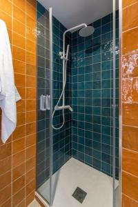 a bathroom with a glass shower with blue tiles at Estudio moderno y acogedor en Madrid Rio nº8 in Madrid