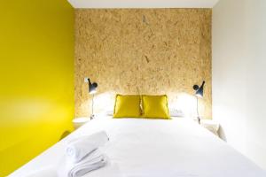 a bedroom with a white bed with two yellow pillows at Estudio moderno y acogedor en Madrid Rio nº8 in Madrid