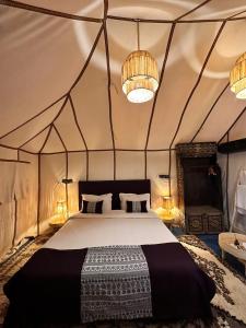 um quarto com uma cama numa tenda em GITE Take Ur time em Merzouga
