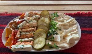 a plate of food with chicken and vegetables on a table at Cottages Jasavić in Plav +17 photos