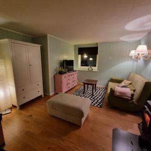 een woonkamer met een bank en een stoel bij Koselig hus med fantastisk utsikt, Stadlandet in Stadlandet
