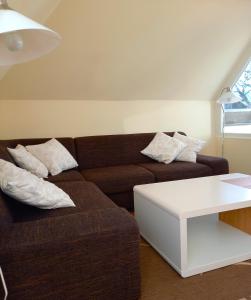 a living room with a brown couch and a white table at Ferienwohnung Sonne und Meer in Ulstrupfeld