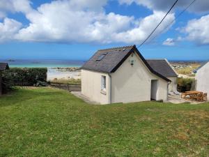 a small white house on the side of a beach at Beach House - jusqu'à 5 personnes in Plouescat