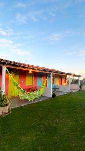 a colorful house with a lawn in front of it at Vila Cajuzinho in Caraíva